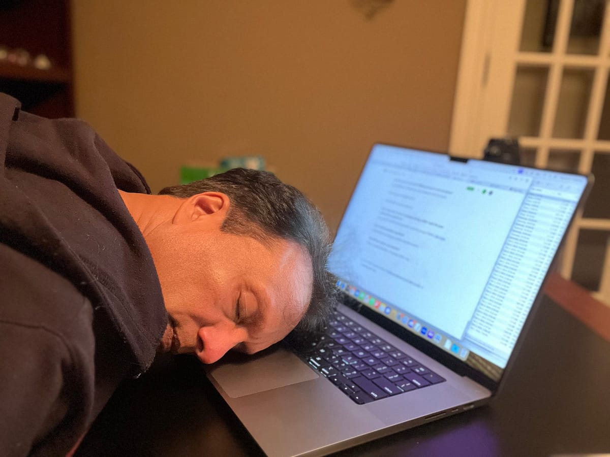 The author asleep face-down on his open laptop