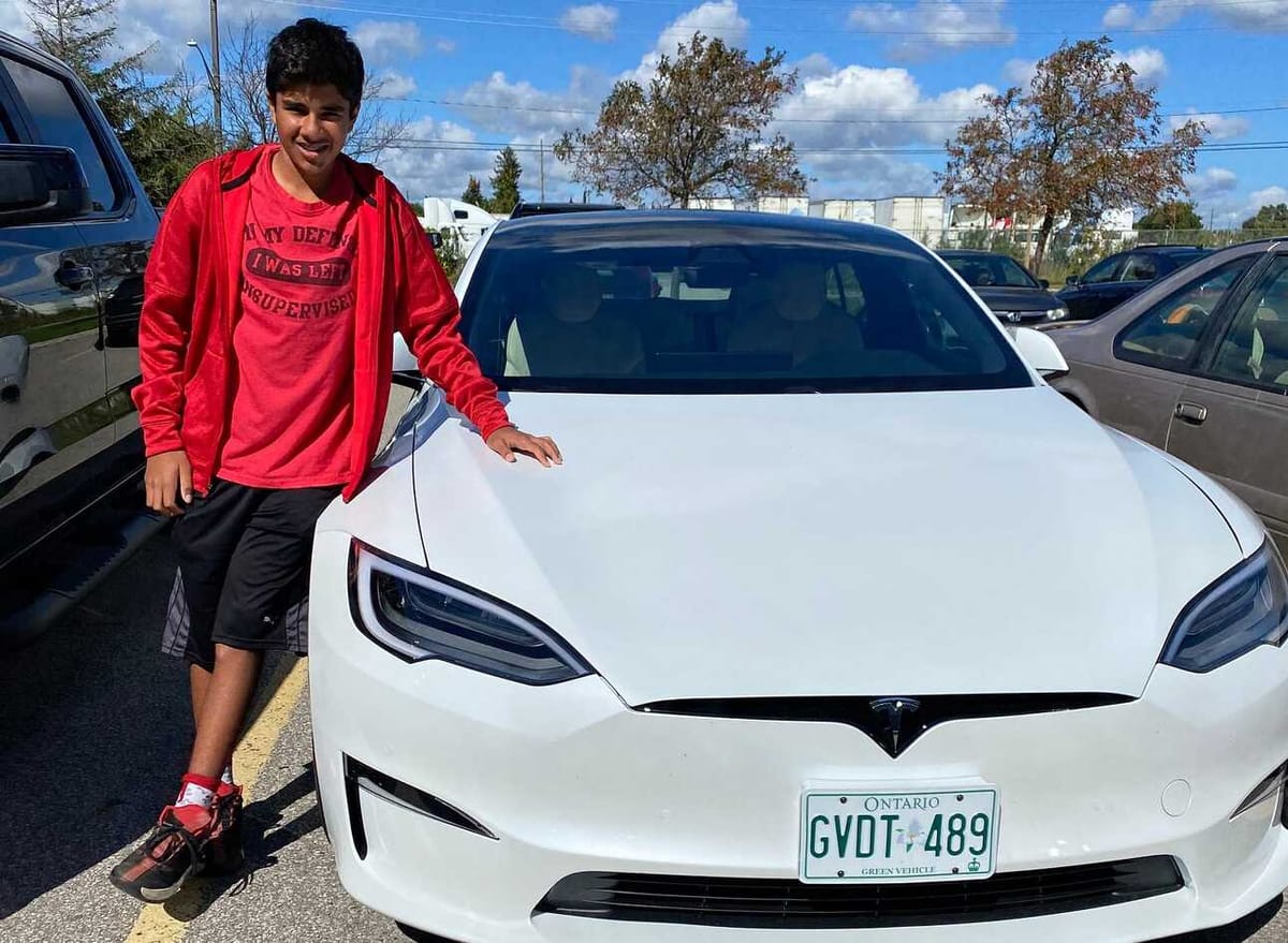 Author’s son posing with white Tesla Model S