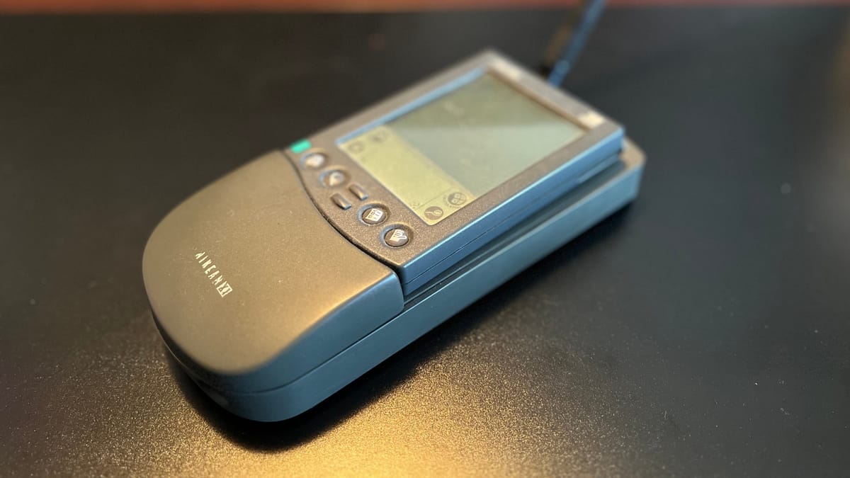 A Palm Pilot in a cradle with a wireless modem